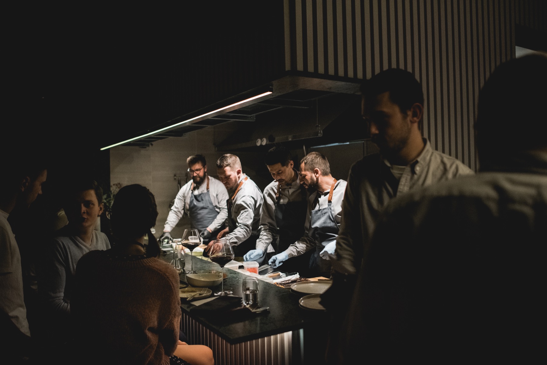 Commons — kitchen team preparing dishes in front of guests at the counter