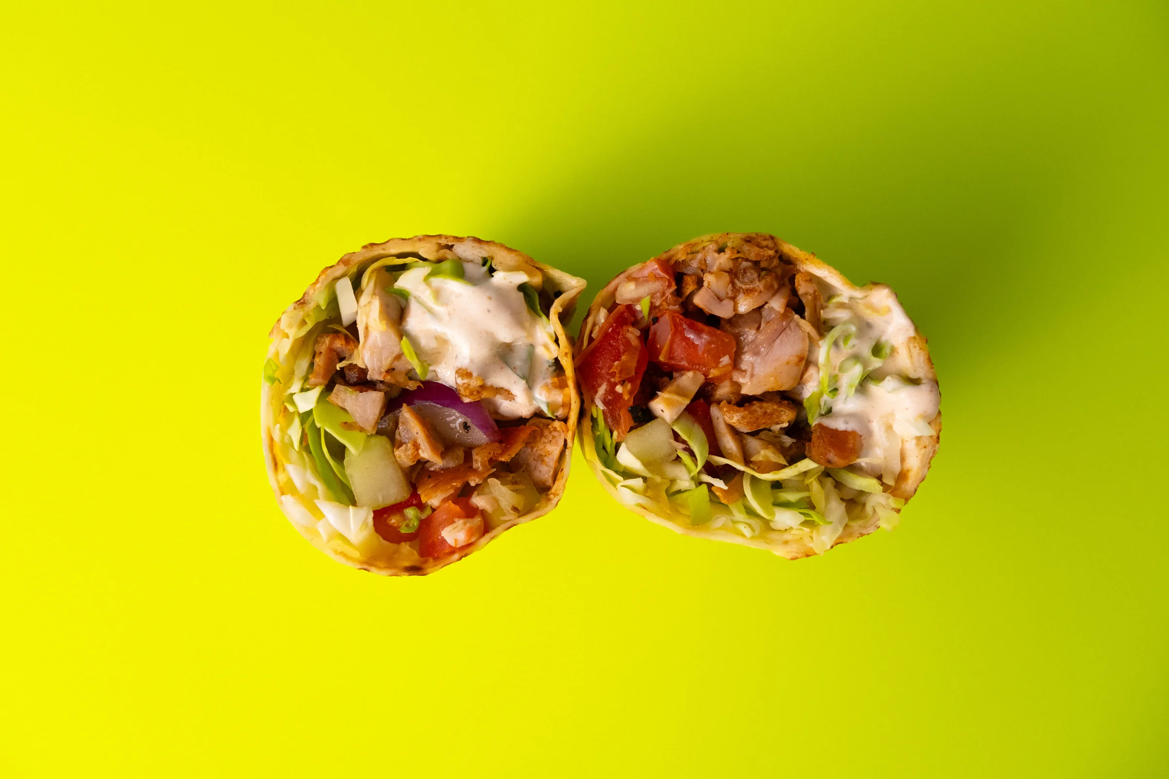 LKS — two kebab halves showing their fillings against a bright yellow background