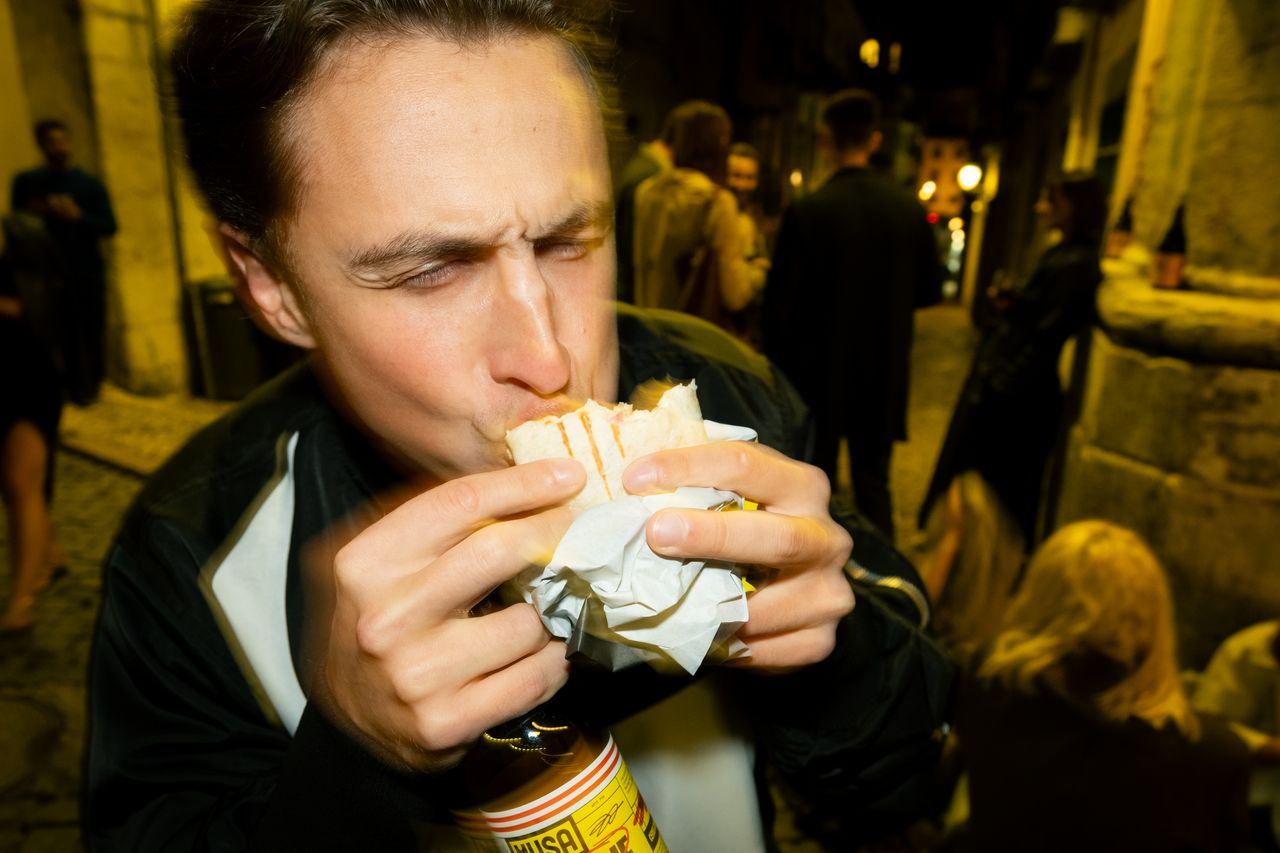 LKS — a guest eating a kebab outside Lisbon Kebab Station