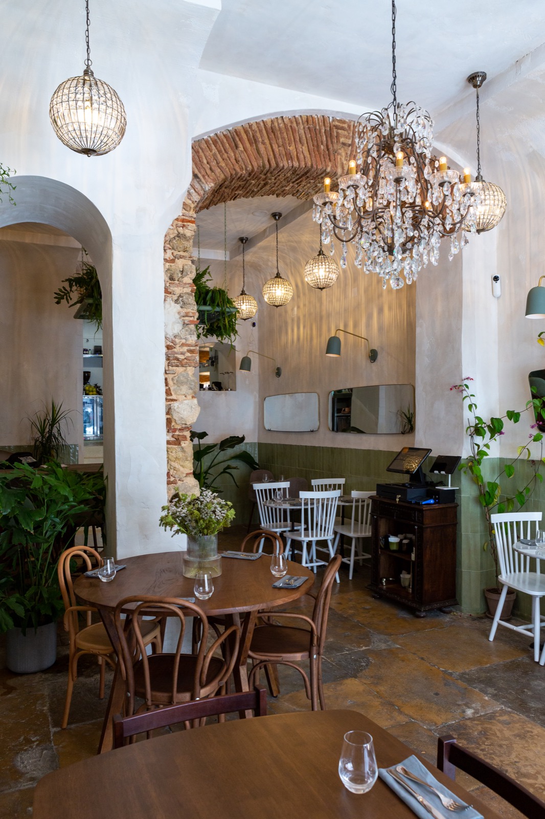 Zula Bistro — brick arch and chandeliers above the dining room